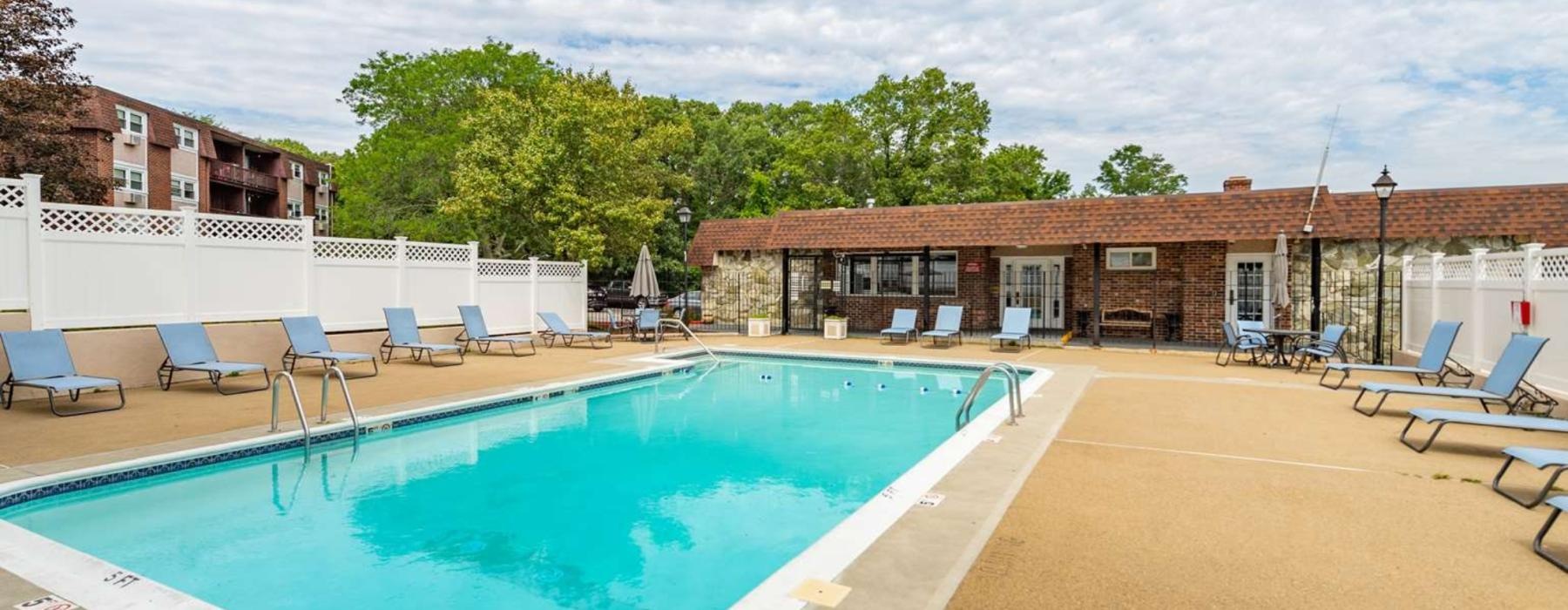 a swimming pool with chairs around it